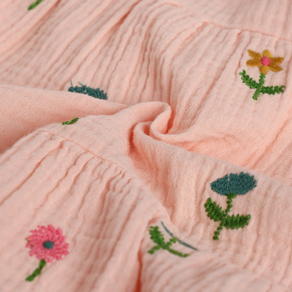 Close-up of pink fabric with embroidered flowers