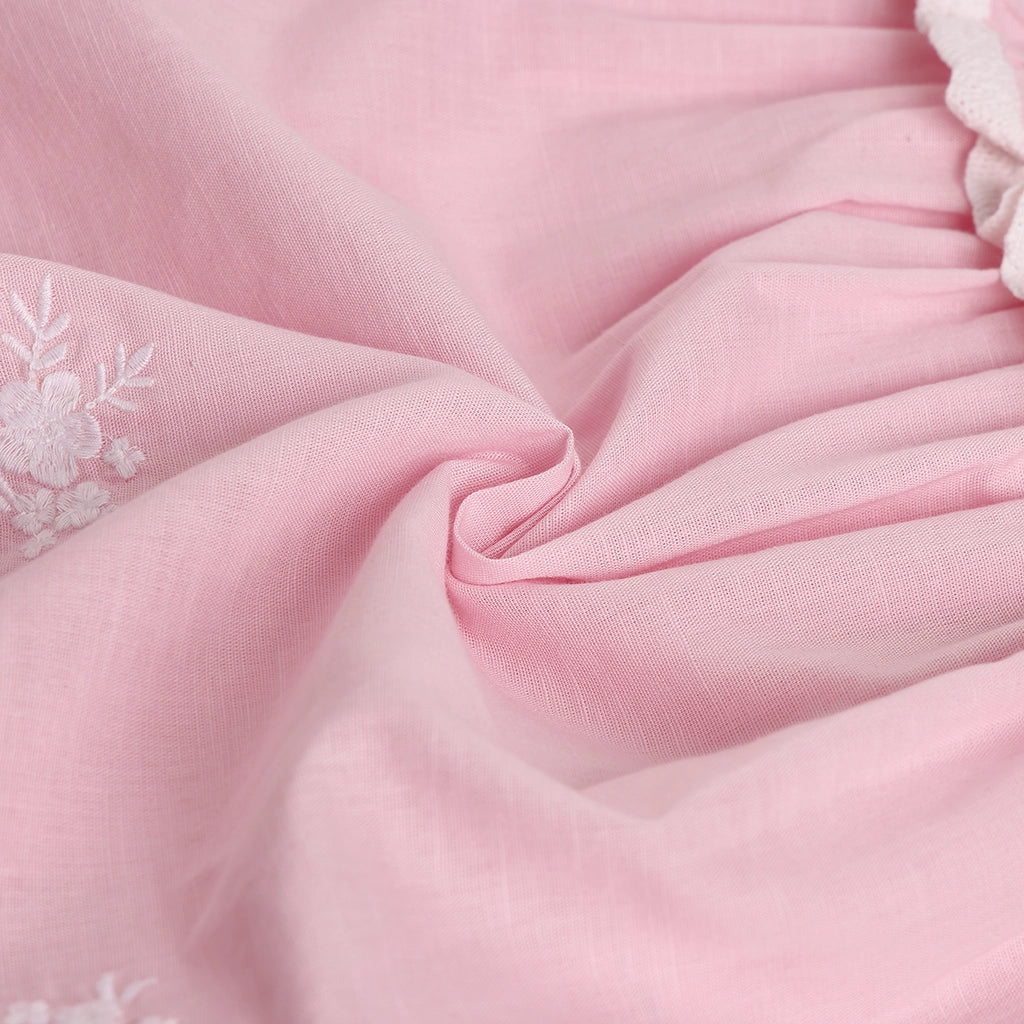 Close-up of pink fabric with floral embroidery