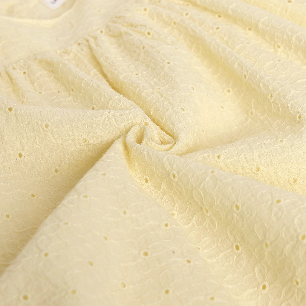 Close-up of textured beige fabric with small holes