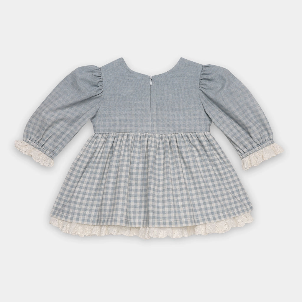 Gray checkered dress with ruffled trim on a white background