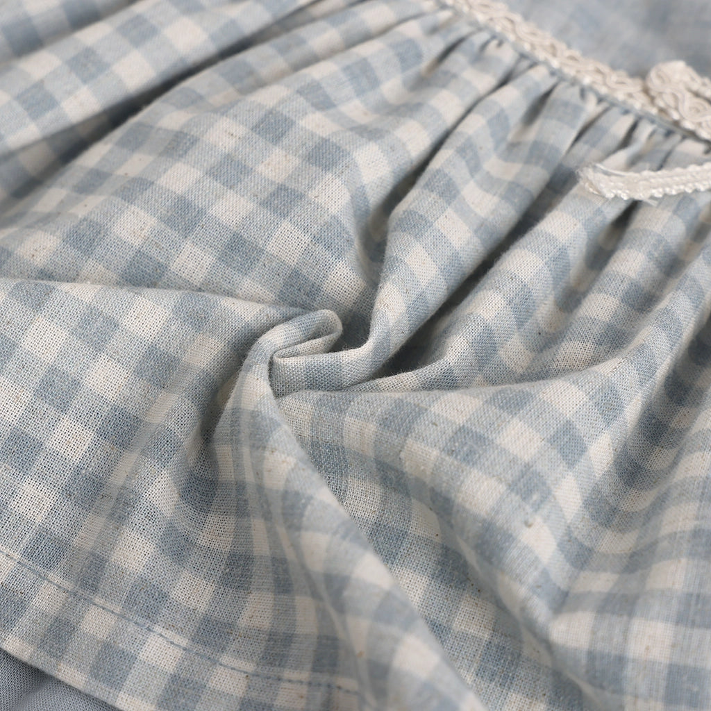 Close-up of blue and white checkered fabric with lace trim