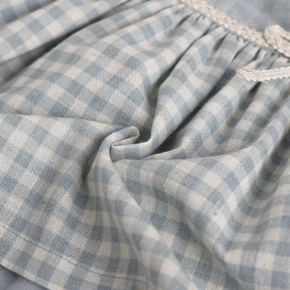 Close-up of blue and white checkered fabric with lace trim