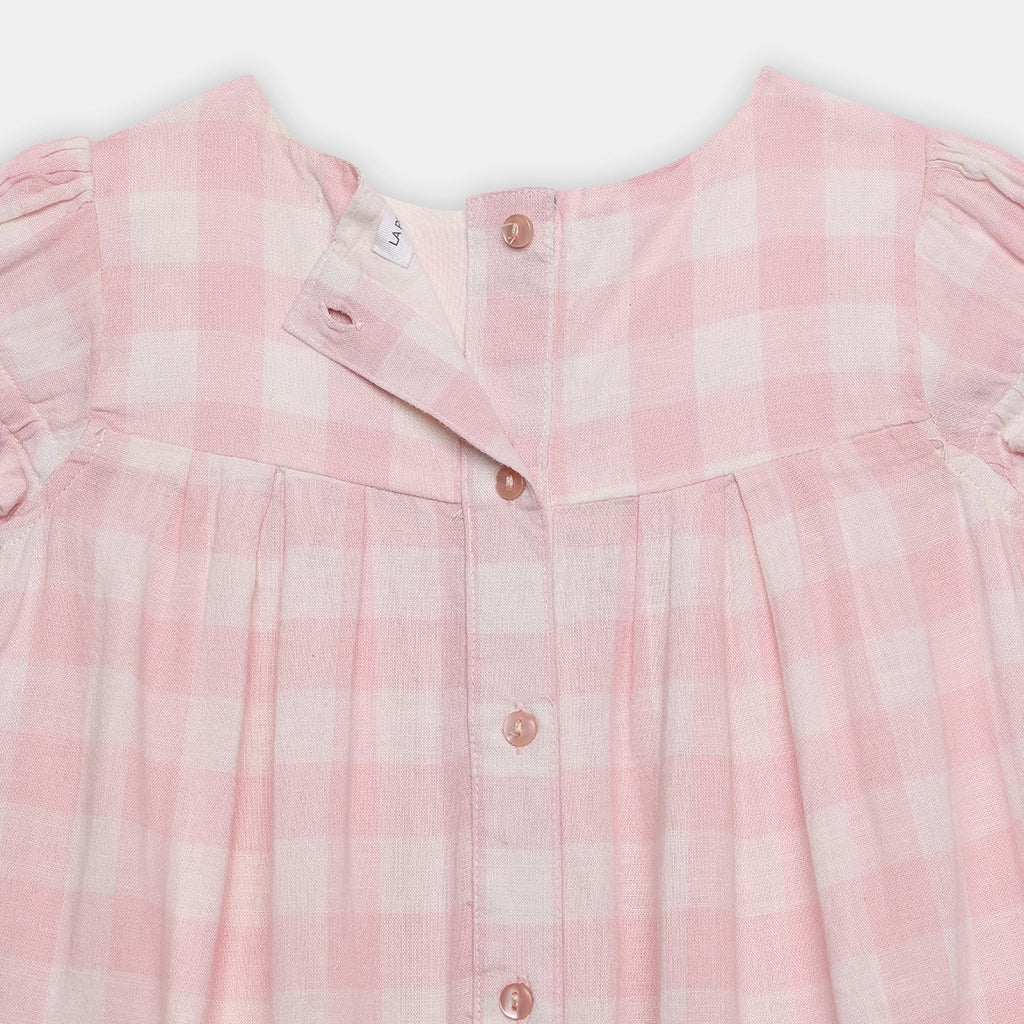 Close-up of a pink checkered shirt with buttons on a white background