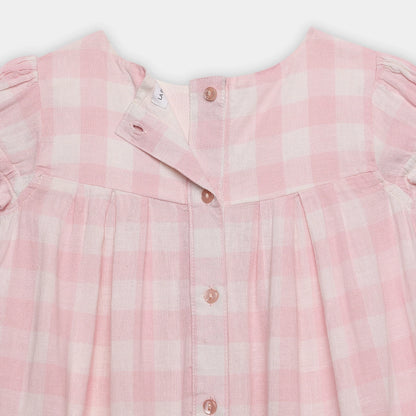 Close-up of a pink checkered shirt with buttons on a white background