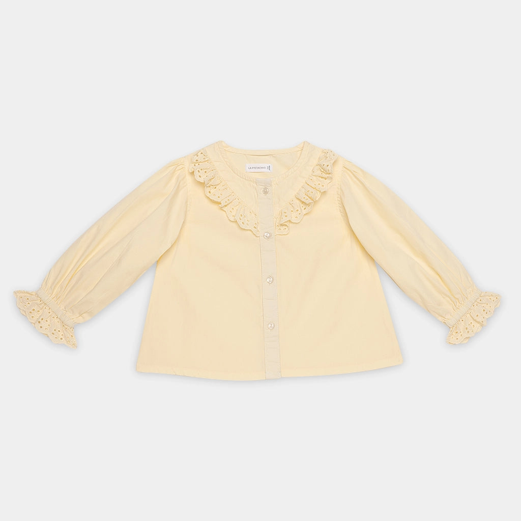 Yellow blouse with ruffled details on a light gray background