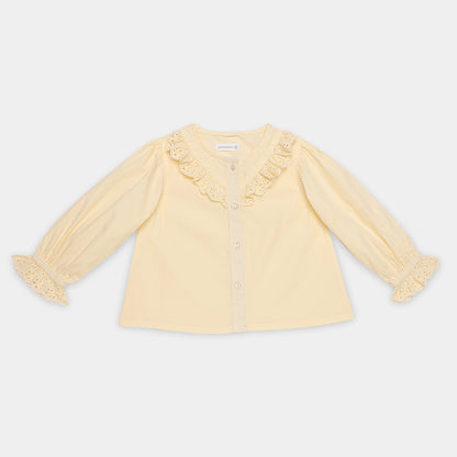 Yellow blouse with ruffled details on a light gray background