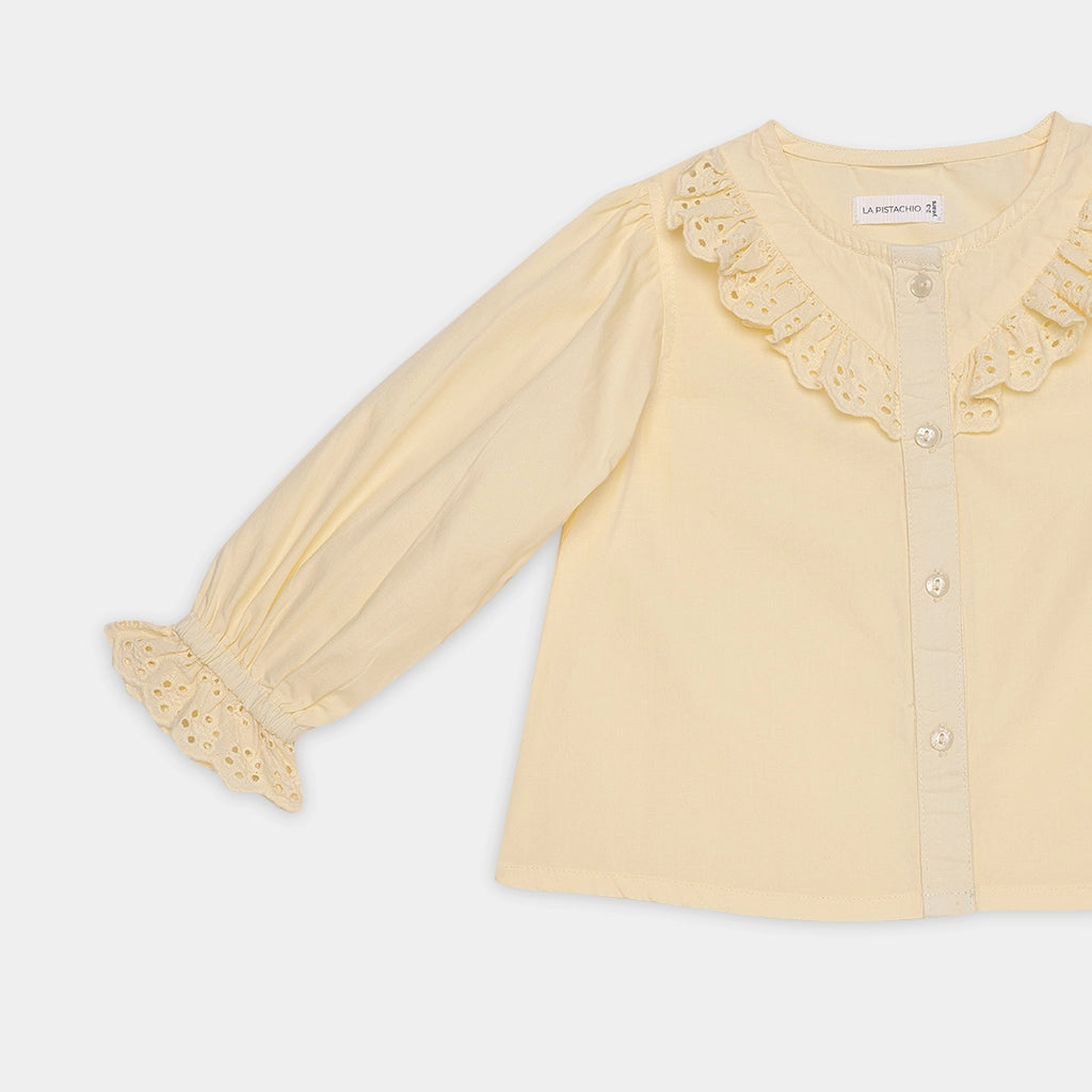 Yellow blouse with lace details on a white background