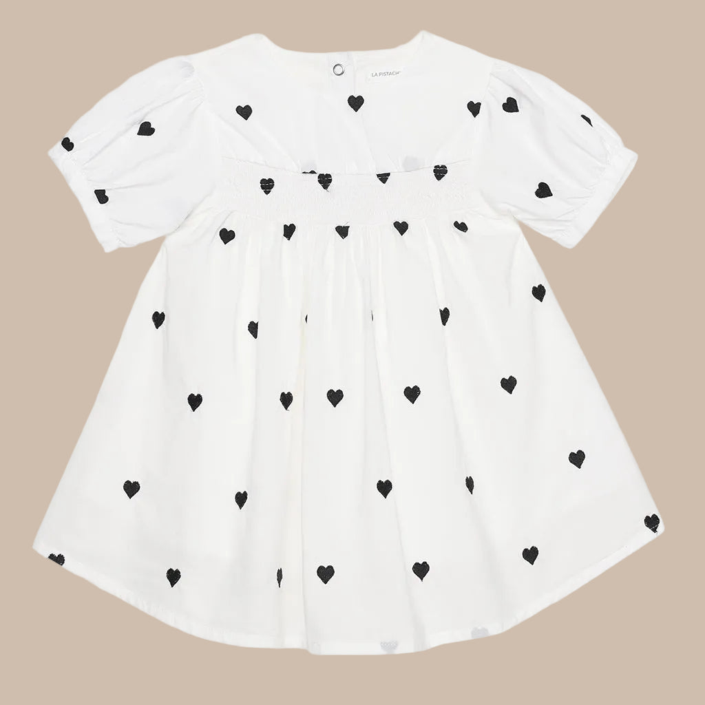 White dress with black heart patterns on a white background