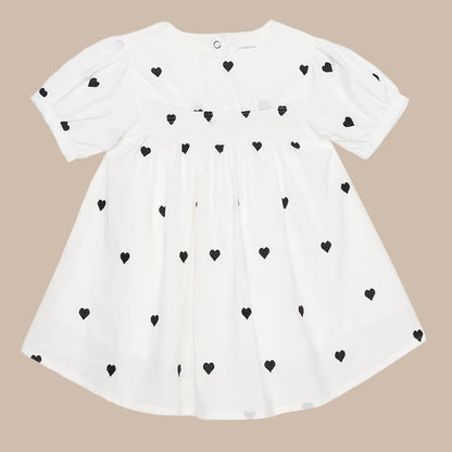White dress with black heart patterns on a white background