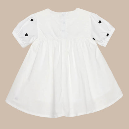 White dress with black heart details on a white background