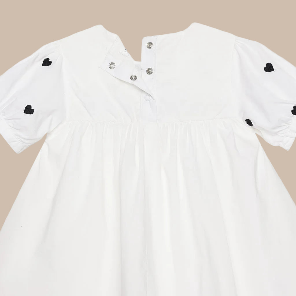 White dress with black heart details on a white background