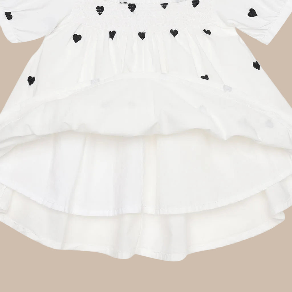 White dress with black heart patterns on a white background