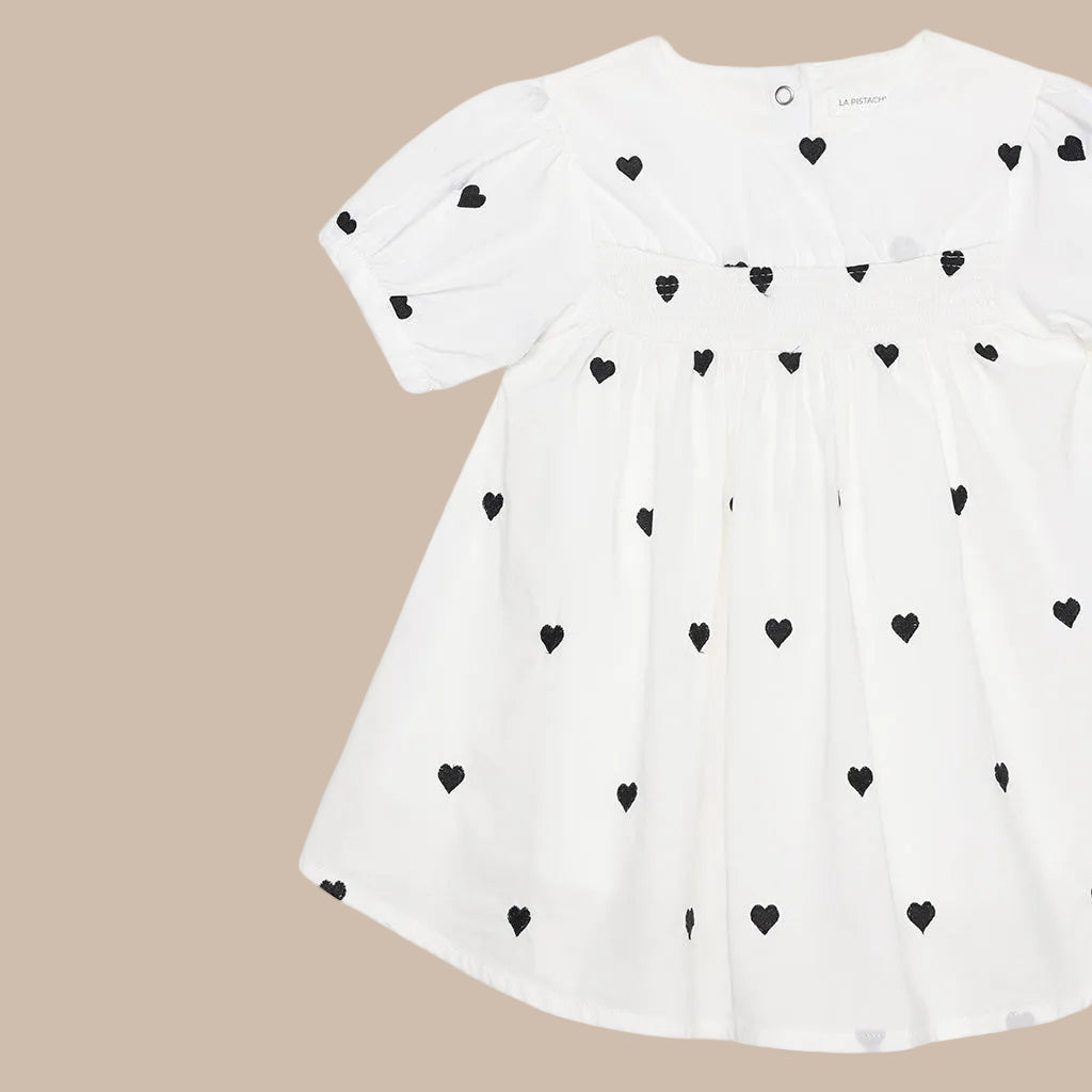 White dress with black heart patterns on a white background
