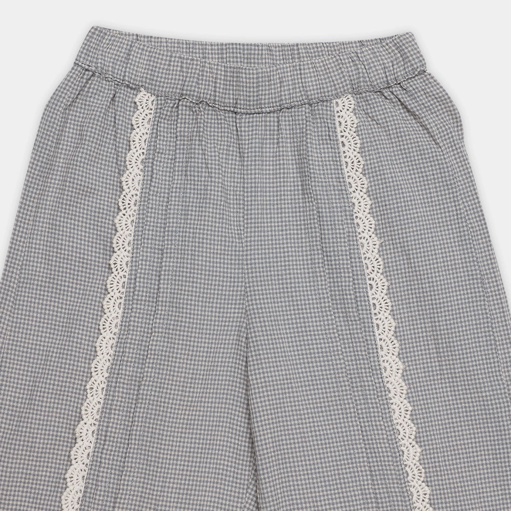 Gray checkered pants with white lace trim on a light gray background