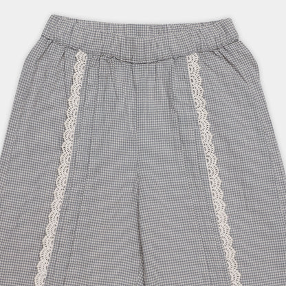 Gray checkered pants with white lace trim on a light gray background