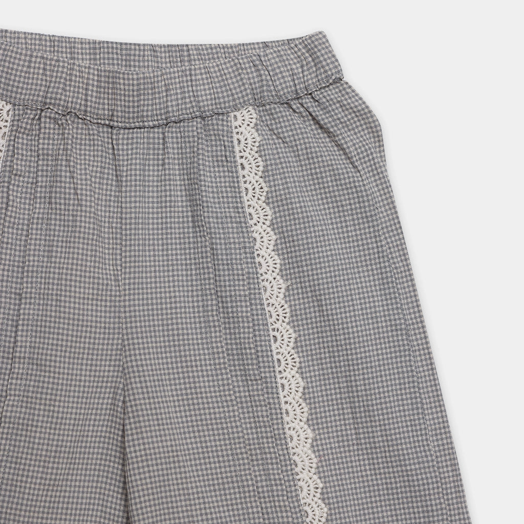 Gray checkered pants with white lace trim on a light gray background