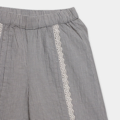 Gray checkered pants with white lace trim on a light gray background