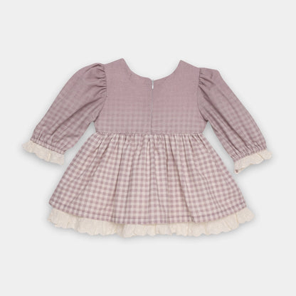 Pink checkered dress with ruffled details on a light gray background