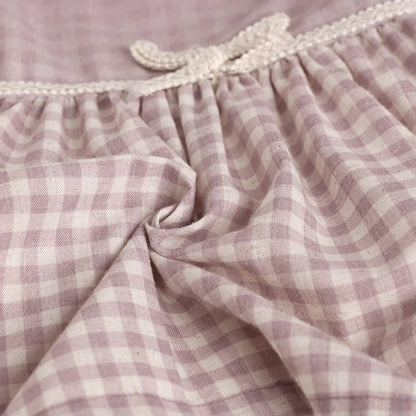Close-up of a purple and white checkered fabric with lace trim.