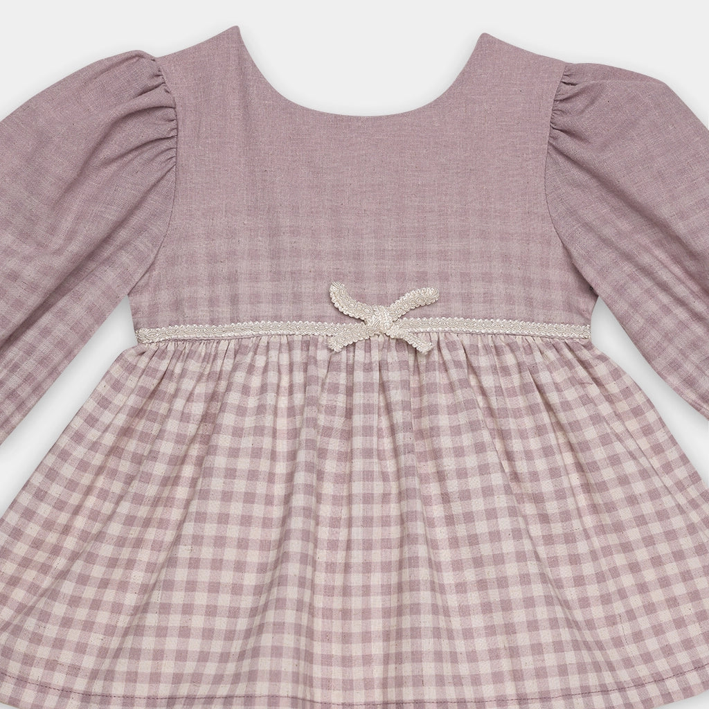 Pink checkered dress with lace detail on a white background