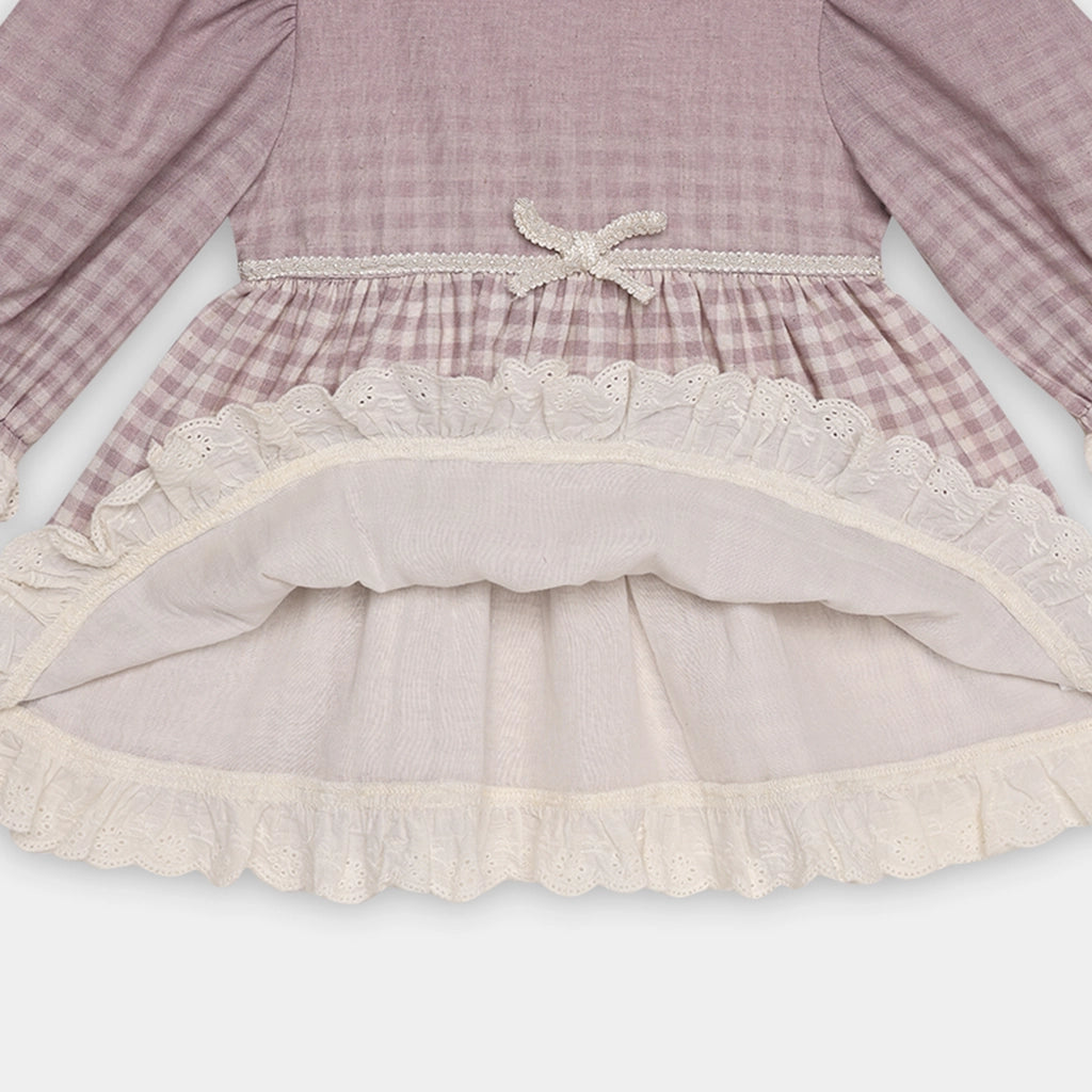Close-up of a dress with ruffled hem and plaid pattern on a white background