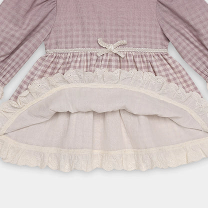 Close-up of a dress with ruffled hem and plaid pattern on a white background
