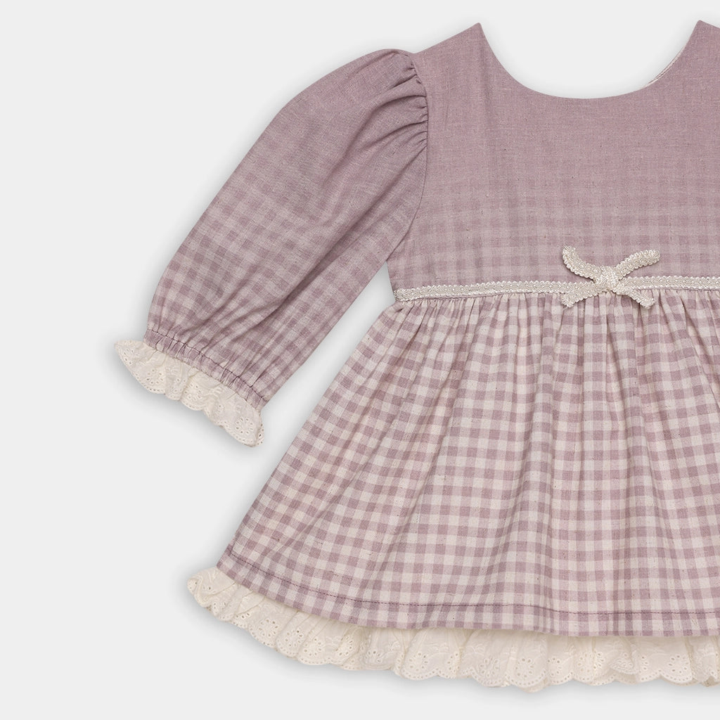 Pink checkered dress with lace trim on a white background