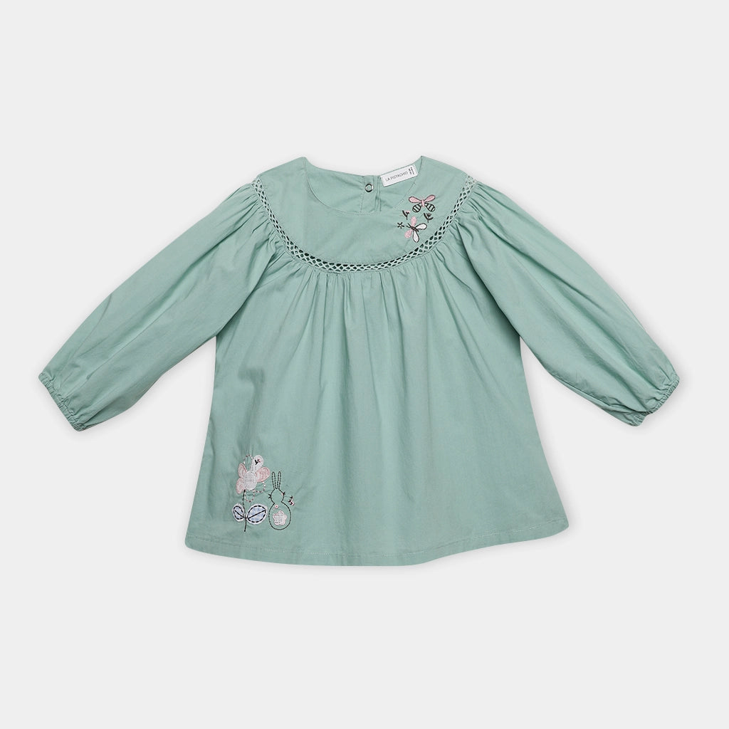 Green blouse with floral embroidery on a white background