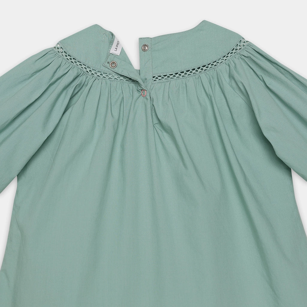 Green dress with lace details on a white background
