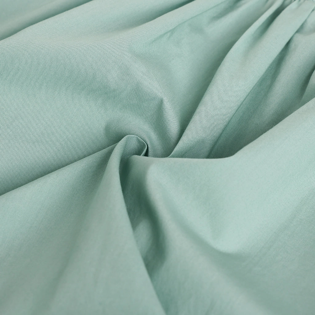 Close-up of light green fabric with folds