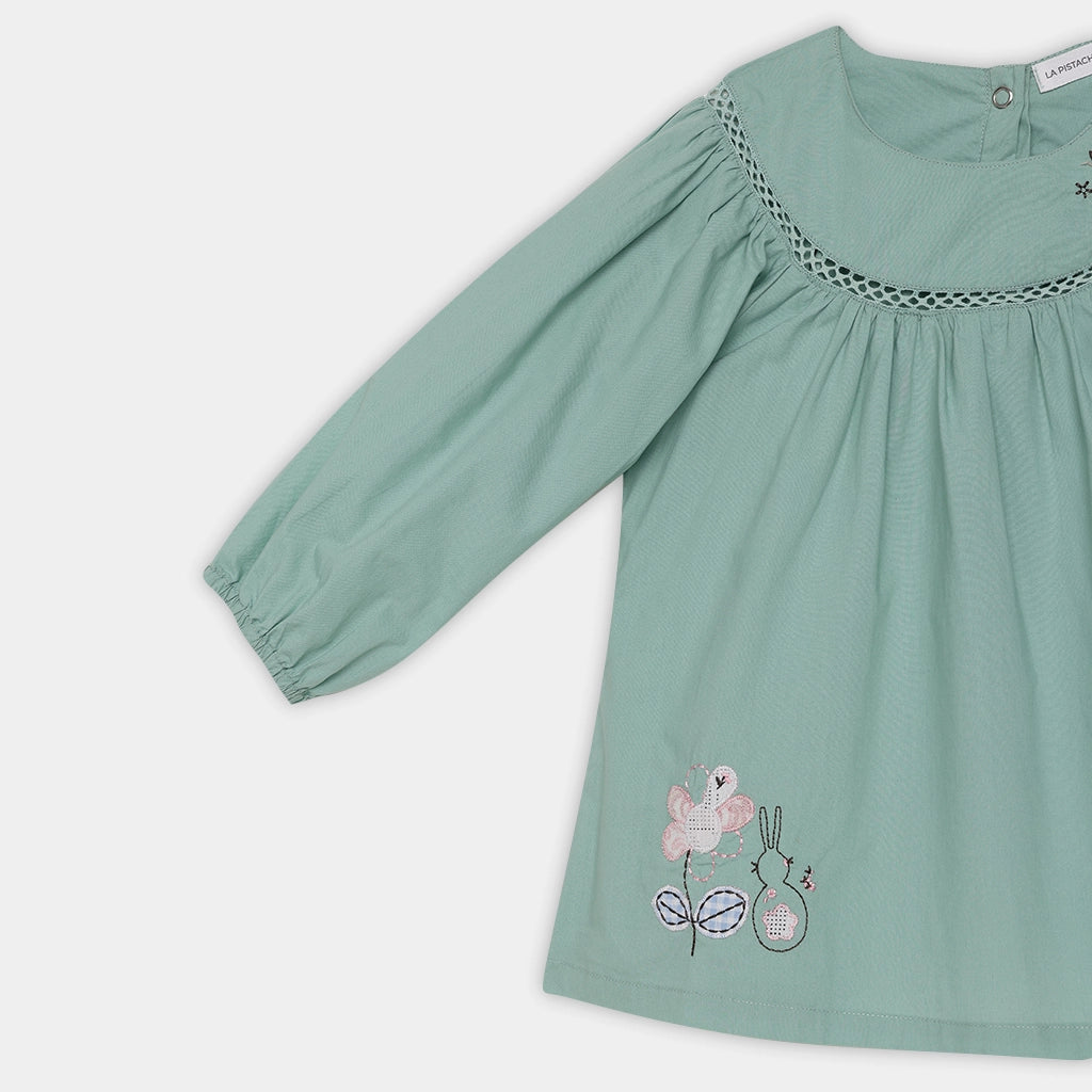 Green dress with floral embroidery on a white background