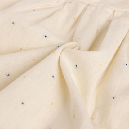 Close-up of beige fabric with small specks, possibly cotton or linen.