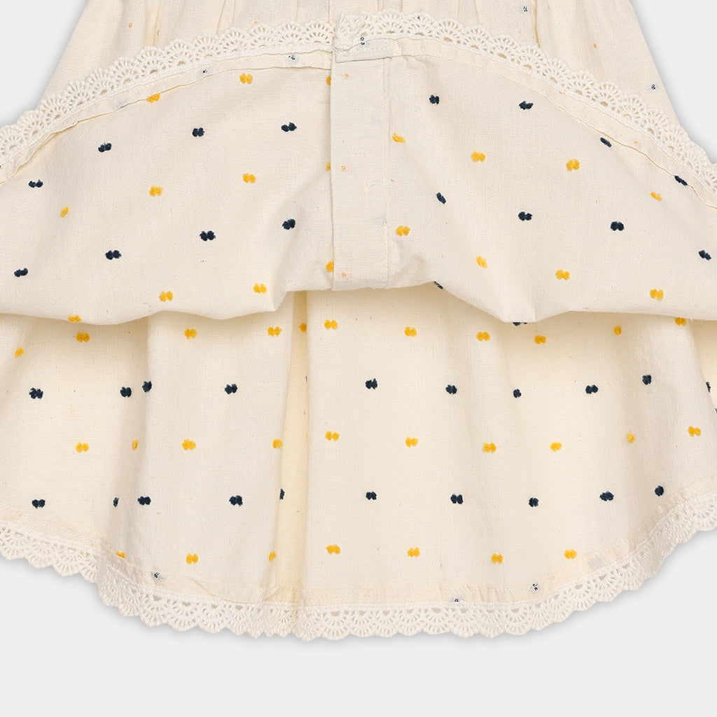Beige skirt with black and yellow polka dots on a light gray background