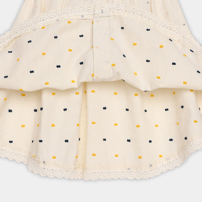 Beige skirt with black and yellow polka dots on a light gray background