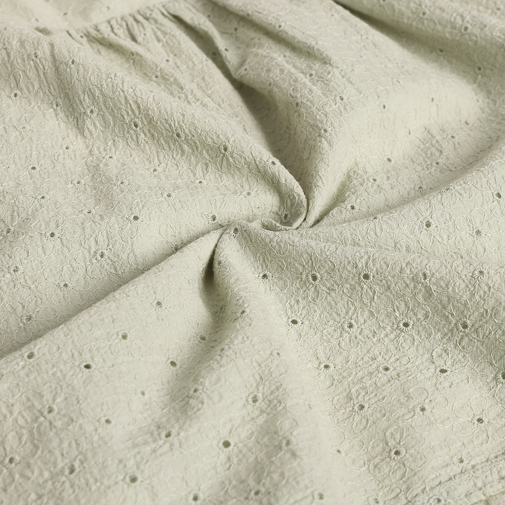 Close-up of textured beige fabric with small holes