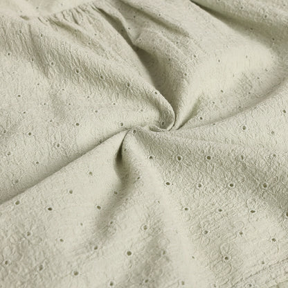 Close-up of textured beige fabric with small holes