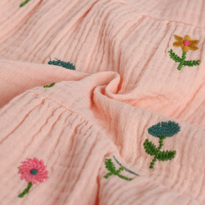Close-up of pink fabric with embroidered flowers