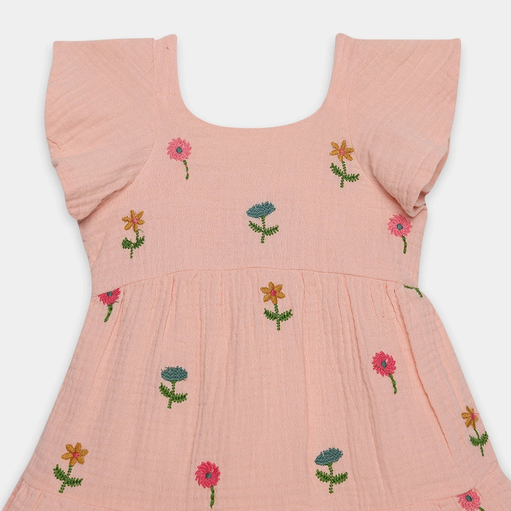 Pink dress with floral embroidery on a white background