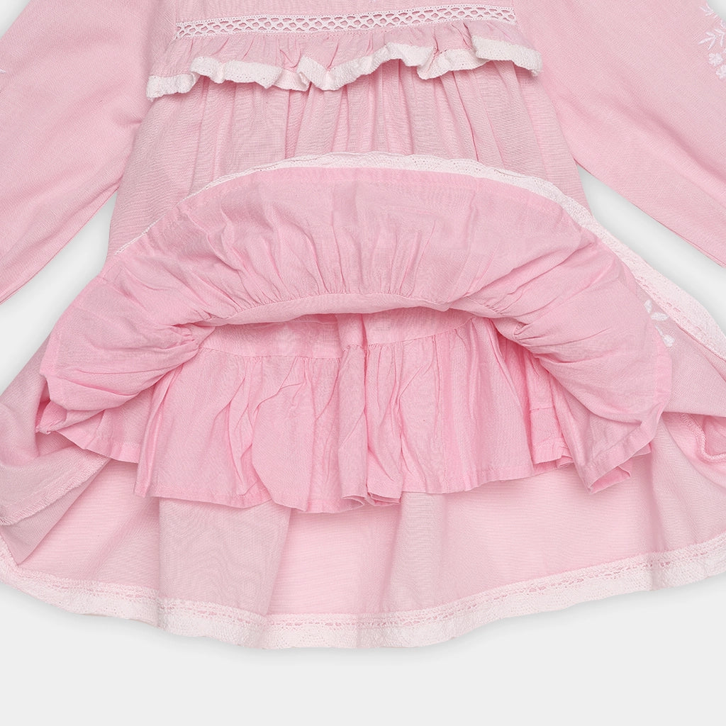 Close-up of a pink dress with ruffled layers on a white background