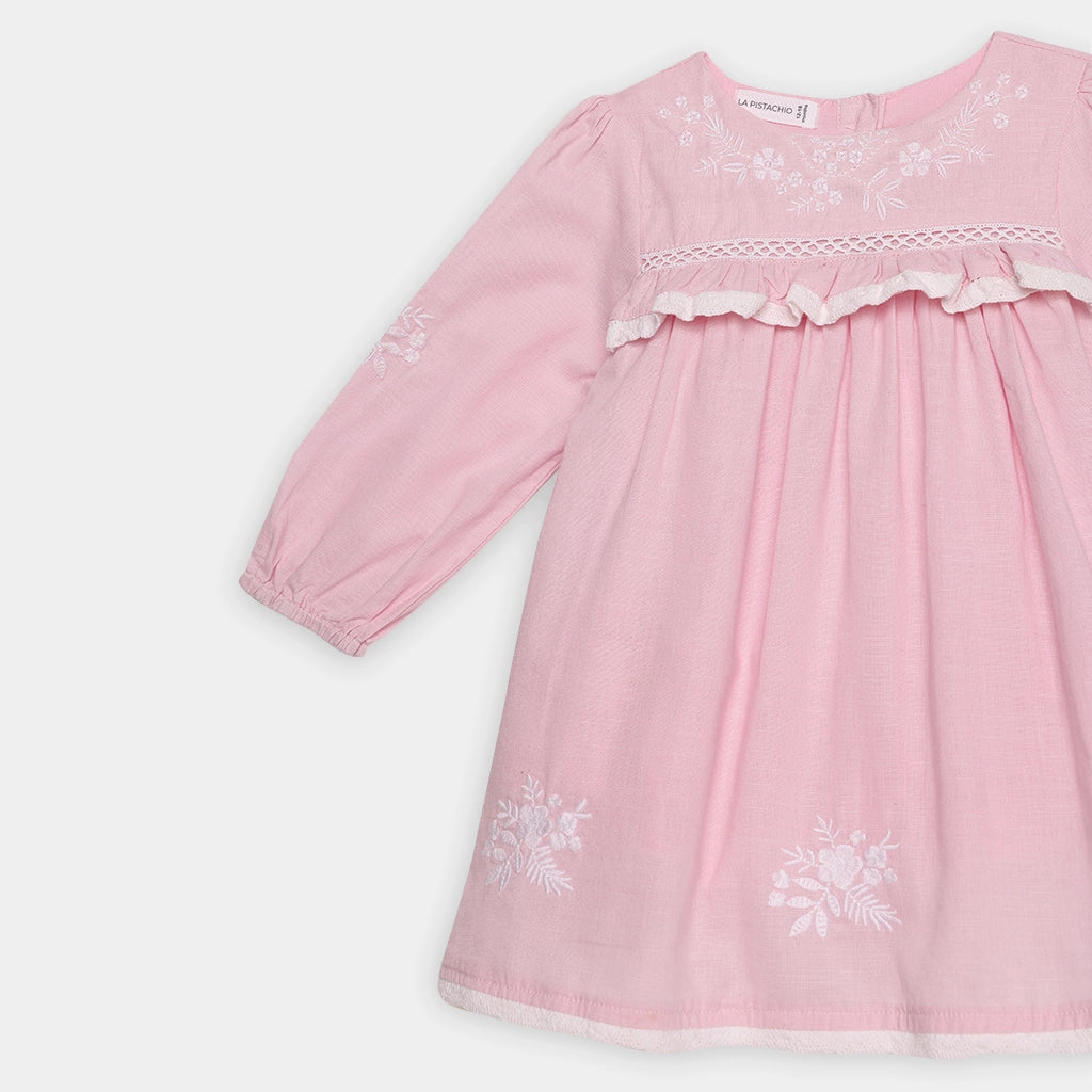 Pink dress with floral embroidery on a white background