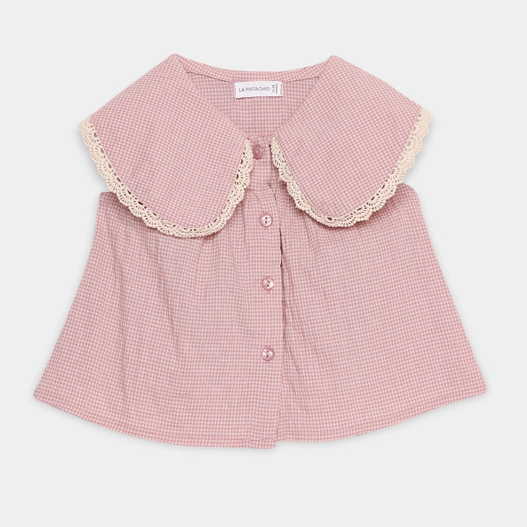 Pink checkered blouse with lace collar on a light gray background