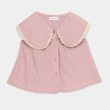Pink checkered blouse with lace collar on a light gray background