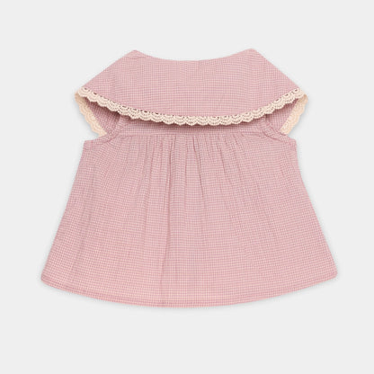 Pink checkered dress with lace trim on a light gray background