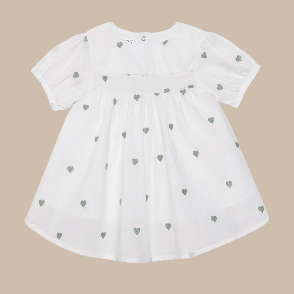 White dress with green heart patterns on a white background