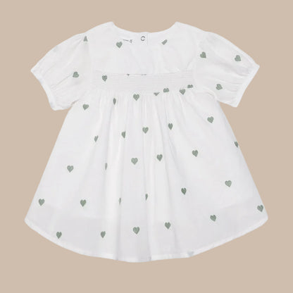 White dress with green heart patterns on a white background