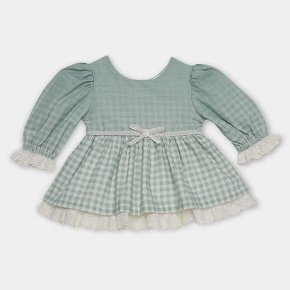 Green checkered dress with long sleeves on a light gray background