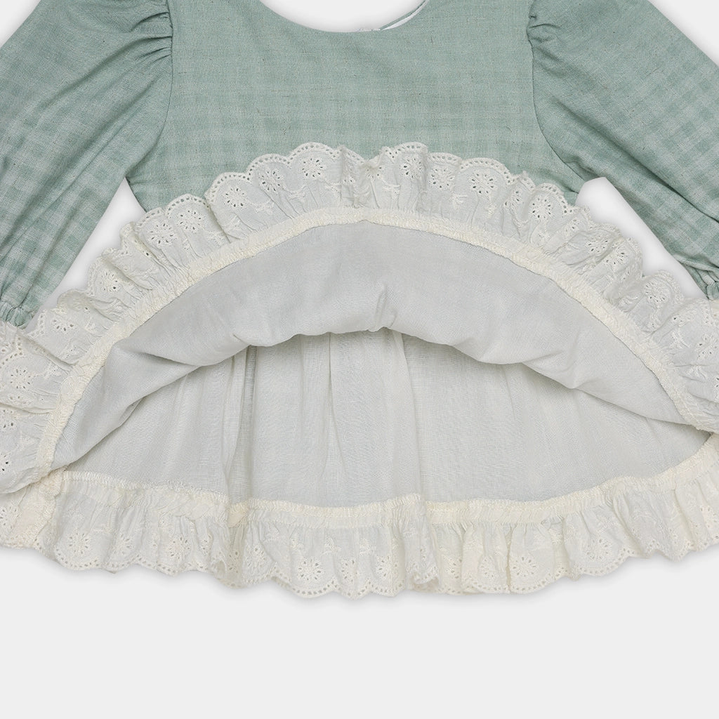 Green dress with lace trim on a white background
