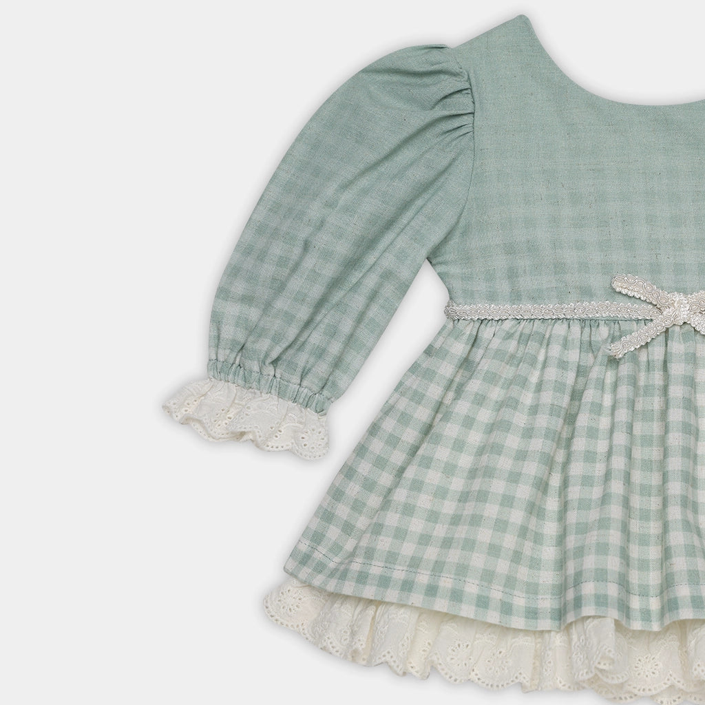 Green checkered dress with lace trim on a white background