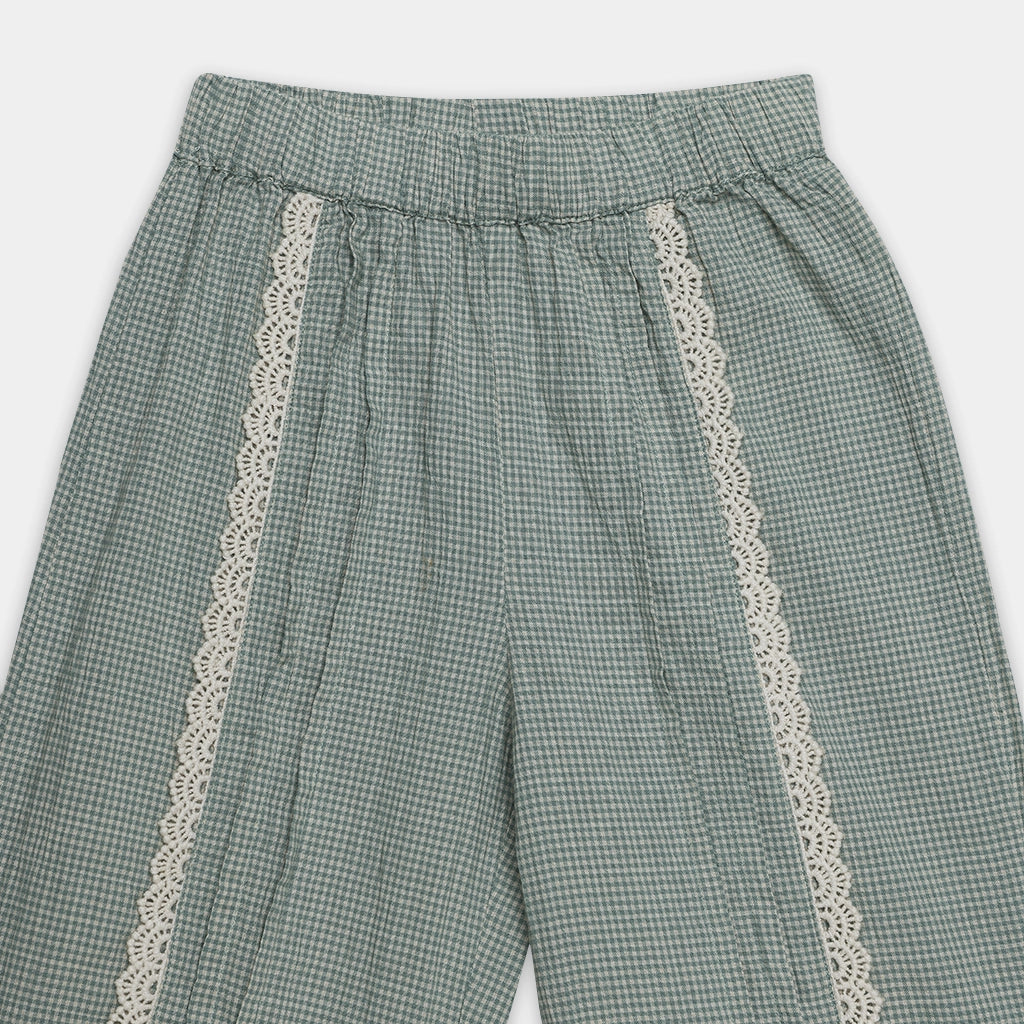 Green checkered pants with lace trim on a white background