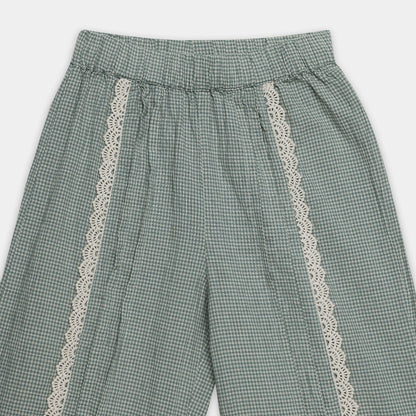 Green checkered pants with lace trim on a white background